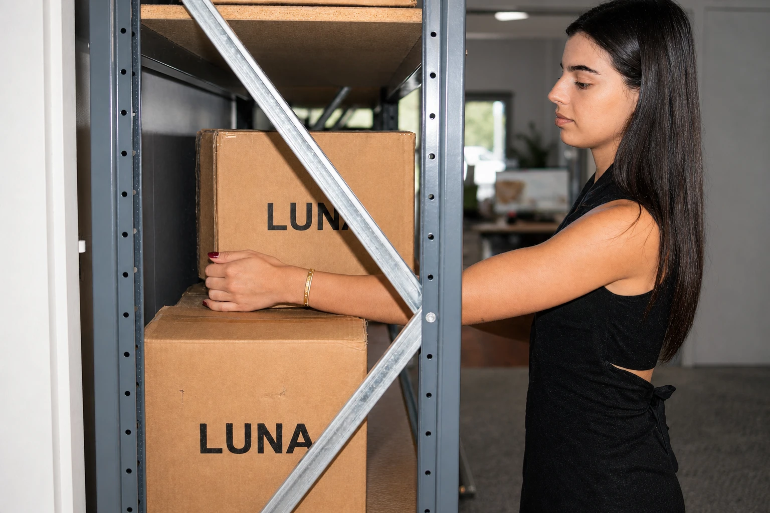 Luna Rae team member packing Luna Rae orders on warehouse shelving Luna Rae team member packing Luna Rae orders on warehouse shelving